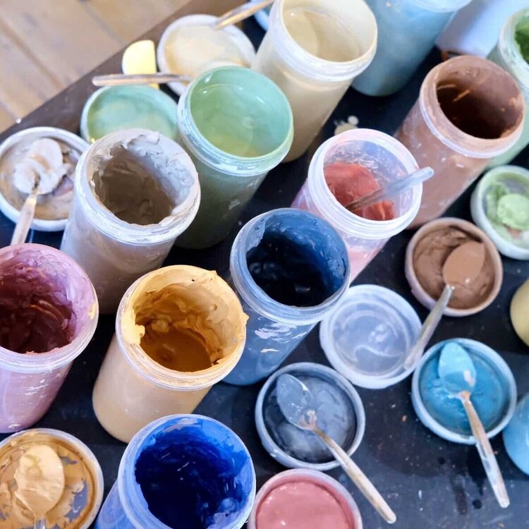 A range of clay paints and glazes arranged on a table at ceramics studio Trylla Bristol